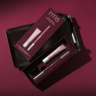 RMS lip kit with gloss, pencil, and sharpener in a dark red box on a matching background.