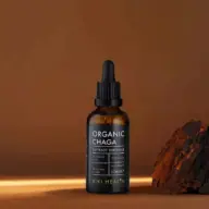 Brown bottle of Organic Chaga extract tincture, 50ml, next to chaga mushroom piece.