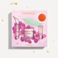 Caudalie gift set with three skincare products, grape illustration, and text "Firming Solution".