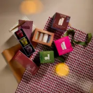 Neom skincare gift sets on patterned wrapping paper with ribbon.