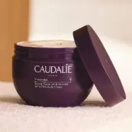 Purple jar of Caudalie Vinosculpt Lift & Firm Body Cream with lid slightly open.