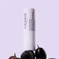 Lip conditioner tube with grapes, text in French and English.