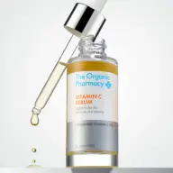 The Organic Pharmacy Vitamin C Serum with dropper and liquid droplet.