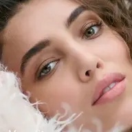 Close-up of a woman's face with curly hair and text "Mossy Stone" in the corner.