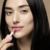 Woman applying pink lip gloss, text "KAROLINA" in corner.