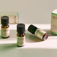 Neom essential oil bottles on a light surface, labels visible.