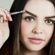Woman using eyebrow brush, text "Dark" in corner.