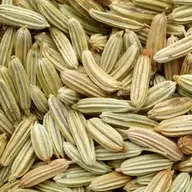 Close-up of dried fennel seeds in various shades of green and brown.