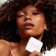 Person holding rms beauty compact, text "BIKINI BEACH" in corner.