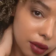 Close-up of a person with curly hair and red lipstick. Text: "PAMELA" in the corner.