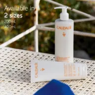 Caudalie lotion bottles on a patterned table, available in 200mL and 400mL sizes.