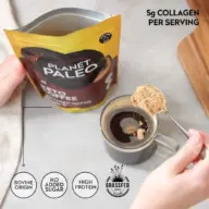 Planet Paleo Keto Coffee with collagen, spoon over mug. Labels: Bovine origin, no added sugar.