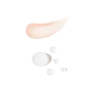 Peach cream smear and white serum droplets on black background.