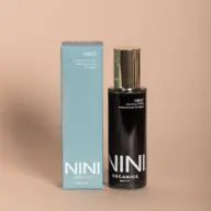 NINI Organics Halo Cleansing Oil Elixir bottle and box on beige background.