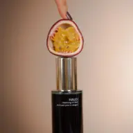 Passion fruit half above Halo Cleansing Oil Elixir bottle.