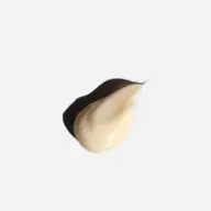 Cream-coloured skincare product dollop on white background.
