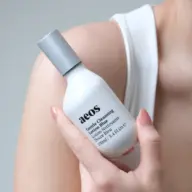 Person holding aeos Gentle Cleansing Lotion Blue, 100ml bottle.
