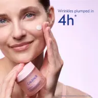 Woman applying Caudalie cream to cheek, text: "Wrinkles plumped in 4h".