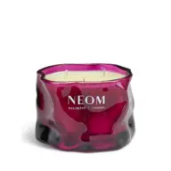Red glass candle with three wicks, labelled "NEOM Wellbeing London".