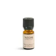 Amber bottle of Neom Tuberose, Cedarwood & Ylang Ylang essential oil blend.