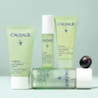 Caudalie Vinopure skincare products with grape on light green background.