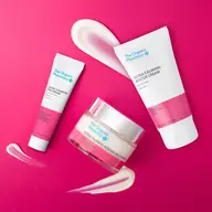 The Organic Pharmacy skincare products on pink background.
