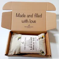Open box with a lavender wheat bag inside. Text: "Made and filled with love".