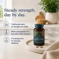 Organic Ashwagandha bottle on a table with a glass of water and nuts in the background.