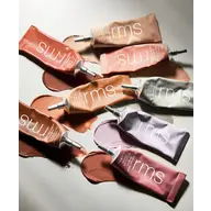 Assorted rms beauty cream tubes on a light surface, various shades visible.