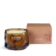 Brown glass candle jar with "NEOM Wellbeing London" text, next to a matching box.
