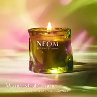 Green candle with flame, labelled "NEOM Wellbeing London". Text: "Moments that Glimmer".