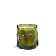 Green glass candle with "NEOM Wellbeing London" text.