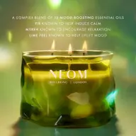 Green NEOM candle with three flames. Text: 13 mood-boosting oils, fir, myrrh, lime peel.