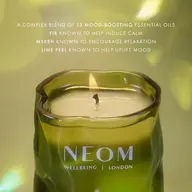 Green NEOM candle with text about mood-boosting essential oils.