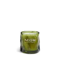 Green glass candle with "NEOM Wellbeing London" text.