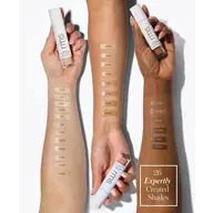 Three arms with 26 foundation shades swatched. Each holds an RMS bottle.
