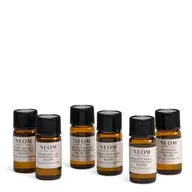Six Neom essential oil bottles with different labels on a white background.