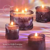 Four lit NEOM candles in purple glass jars, text: "Scent to Help Energise".