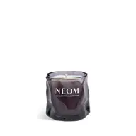 Purple glass candle with "NEOM Wellbeing London" text.