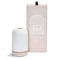 White ceramic essential oil diffuser with packaging. Text: "NEOM Wellbeing Pod".