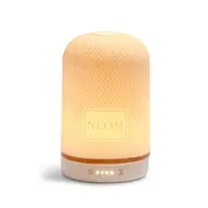 Illuminated NEOM diffuser with textured surface and control icons at the base.