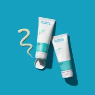 Two tubes of The Organic Pharmacy After Sun Lotion on a blue background.