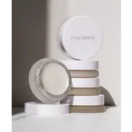 Stack of rms beauty containers with one open, revealing a cream product inside.