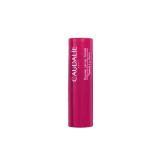 Pink Caudalie tinted lip balm tube with white text.