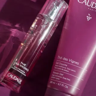 Caudalie Thé des Vignes fragrance and shower gel on a purple background.