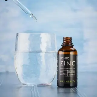 Dropper adding liquid to glass beside Ionic Zinc bottle.
