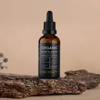 Brown dropper bottle labelled "Organic Lion's Mane Extract Tincture" on wooden surface.