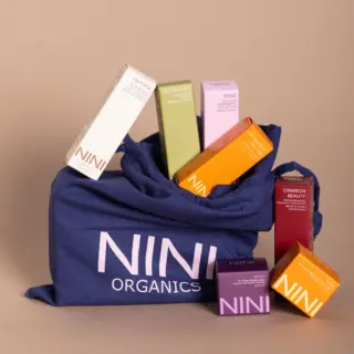NINI Organics products in a blue bag, including boxes labelled Oat Foam, Detox Foam, and Crimson Beauty.