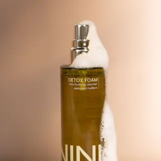 Detox Foam Pore Purifying Cleanser bottle with foam on top.