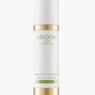White bottle with gold accents, labelled "Abloom Slow Skincare Organic Luminous SPF 20+ Cream Sunkissed".